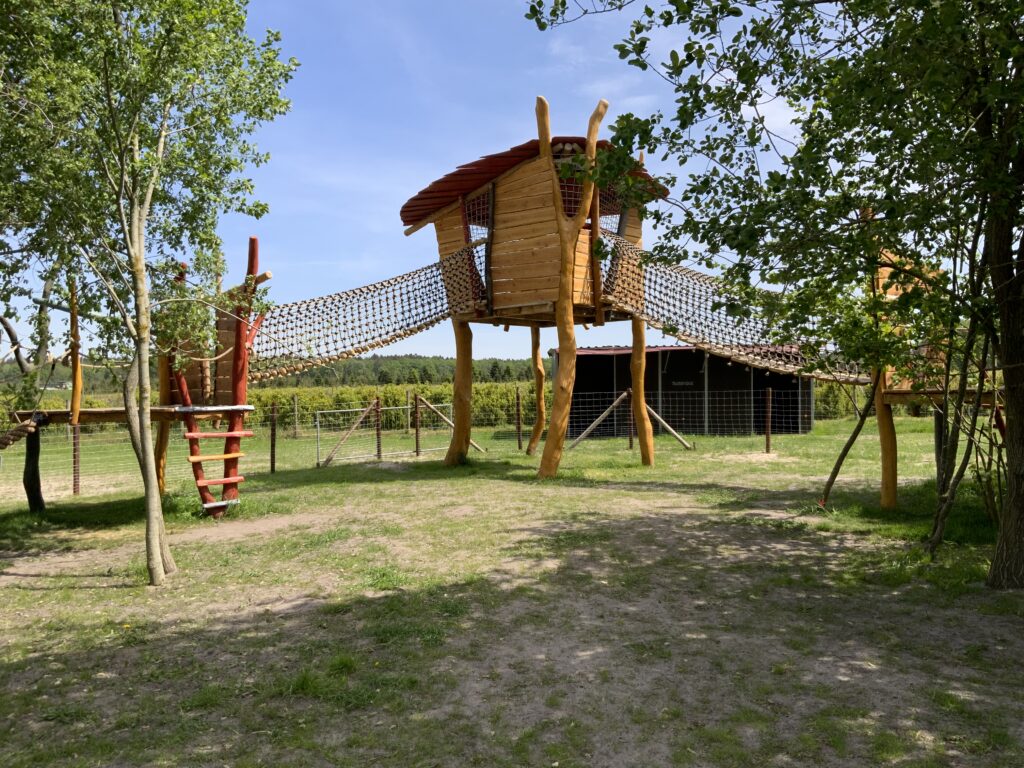 Großes Klettergerüst, dass mit Hängenetzbrücken verbunden ist. Hier wird im Spielplatzbau Robinie verwendet.
